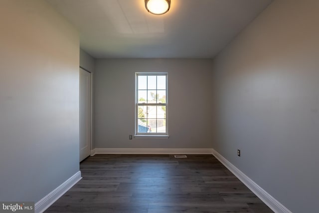 spare room with dark hardwood / wood-style flooring