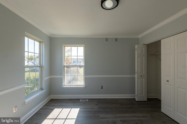 unfurnished bedroom featuring crown molding, a closet, and dark hardwood / wood-style flooring