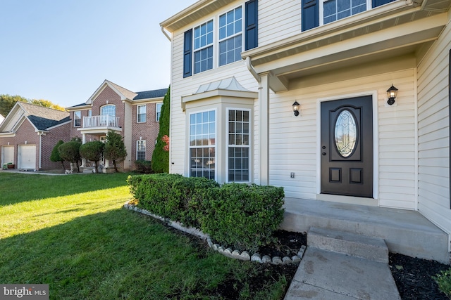 property entrance featuring a balcony and a lawn