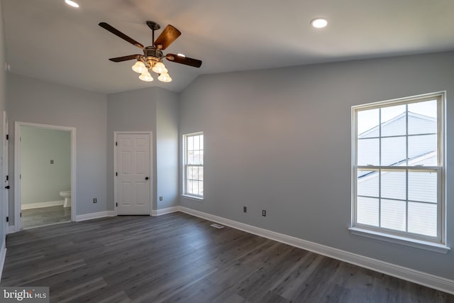 empty room with ceiling fan, vaulted ceiling, and dark hardwood / wood-style flooring