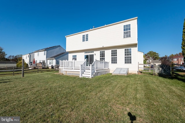 rear view of house featuring a deck and a yard