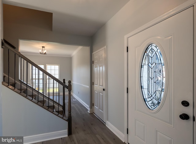 entrance foyer with crown molding, a notable chandelier, and dark hardwood / wood-style floors