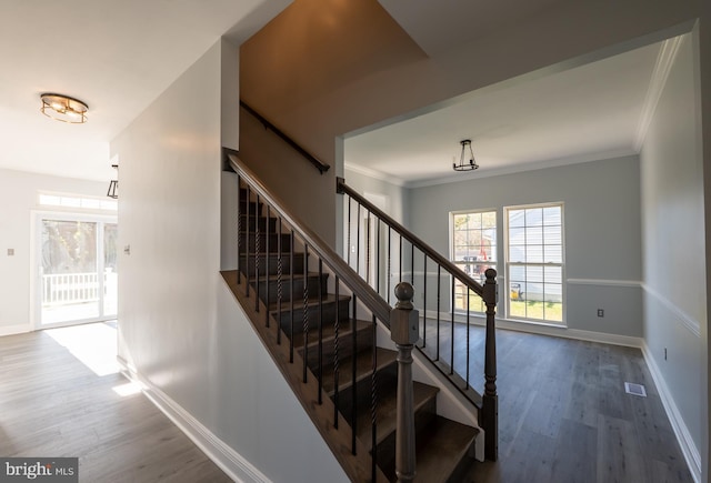 stairway featuring hardwood / wood-style flooring and ornamental molding