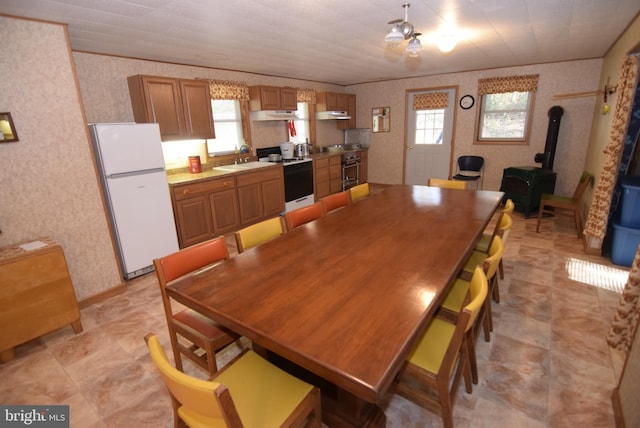 dining area with a wood stove, sink, and plenty of natural light