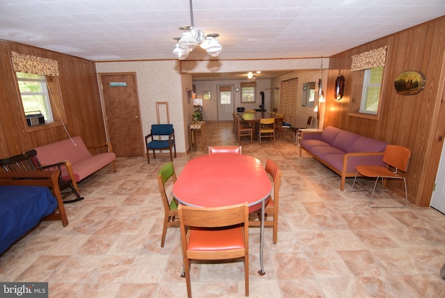 dining room featuring a chandelier and wood walls