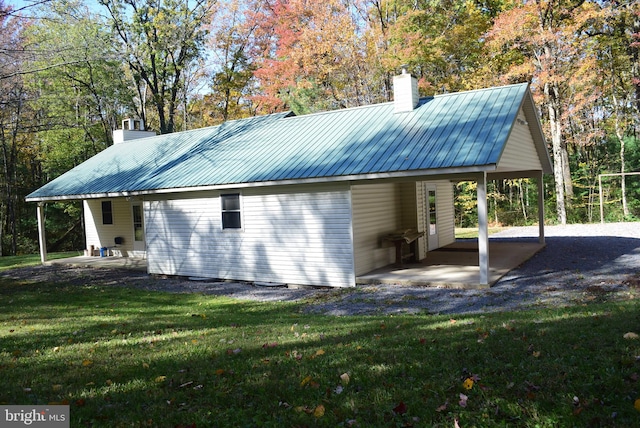 view of home's exterior featuring a patio area, a lawn, and a carport