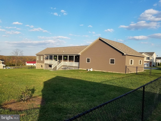 rear view of house featuring a lawn and a sunroom