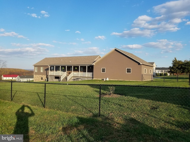 back of property featuring a sunroom and a yard