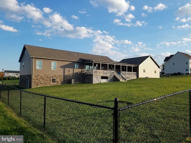 back of property featuring a lawn and a sunroom