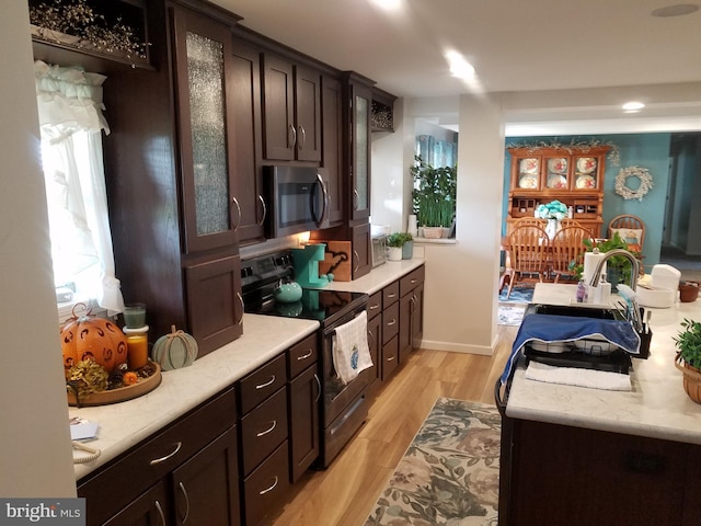 kitchen with light hardwood / wood-style floors, dark brown cabinetry, sink, and appliances with stainless steel finishes