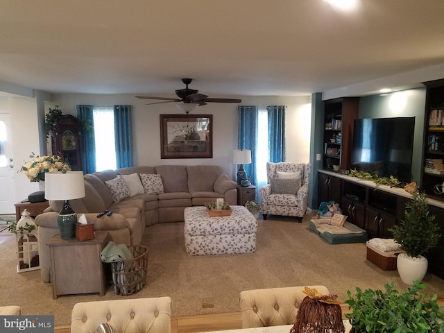 carpeted living room with ceiling fan