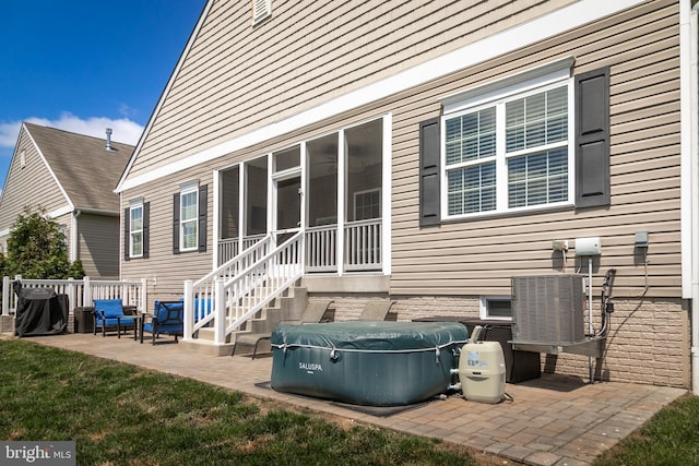 rear view of property with a patio, central AC unit, and a sunroom