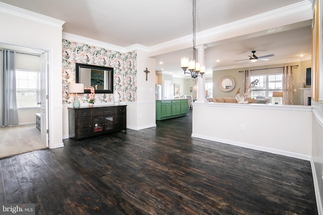 interior space featuring dark wood-type flooring, crown molding, and ceiling fan with notable chandelier