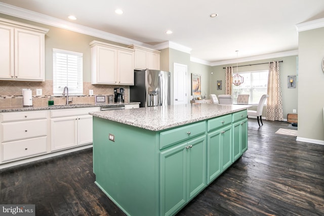 kitchen featuring dark hardwood / wood-style flooring, a kitchen island, sink, crown molding, and stainless steel appliances