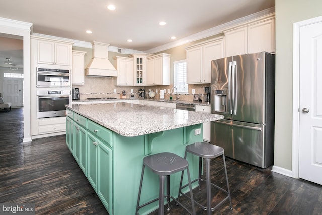 kitchen with green cabinetry, a center island, stainless steel appliances, custom exhaust hood, and dark wood-type flooring