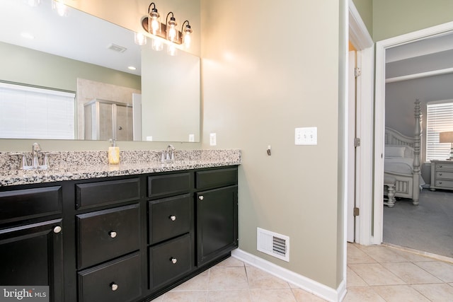 bathroom featuring vanity, tile patterned floors, and a shower with door