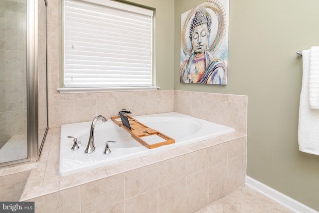 bathroom with independent shower and bath and tile patterned flooring