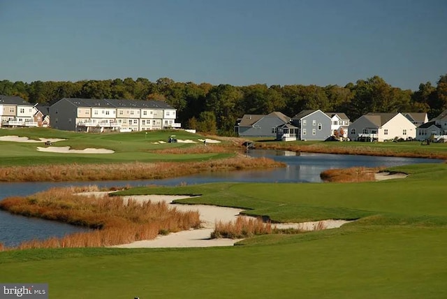 view of community with a lawn and a water view