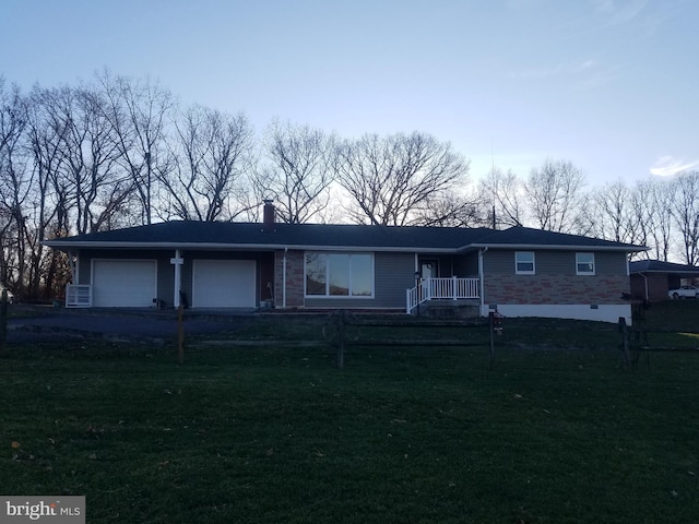 single story home with a front yard and a garage