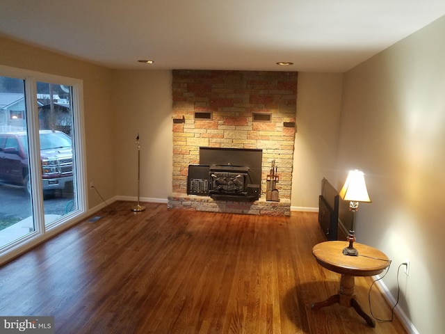 unfurnished living room with a wood stove and hardwood / wood-style flooring