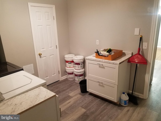 laundry area featuring washer and clothes dryer, dark hardwood / wood-style flooring, and cabinets