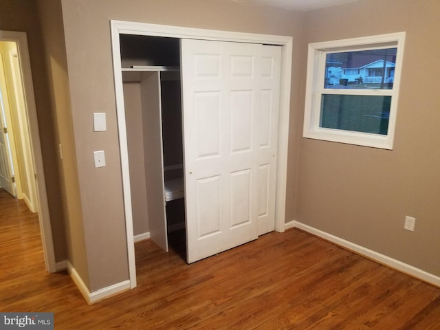 unfurnished bedroom with hardwood / wood-style floors and a closet