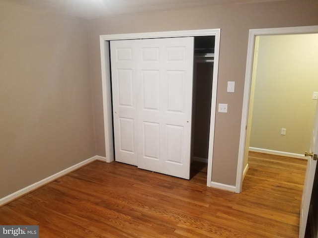 unfurnished bedroom featuring hardwood / wood-style flooring and a closet