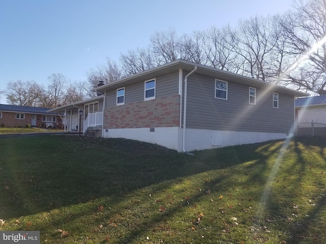 view of home's exterior featuring covered porch and a yard