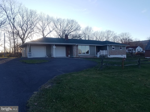 single story home with a garage and a front lawn