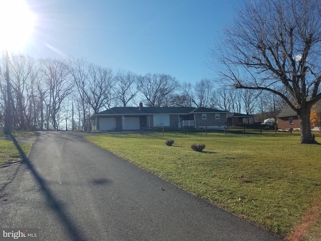 view of front of home with a garage and a front lawn