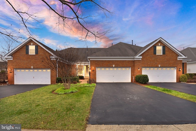 traditional home featuring brick siding, a shingled roof, a garage, driveway, and a front lawn