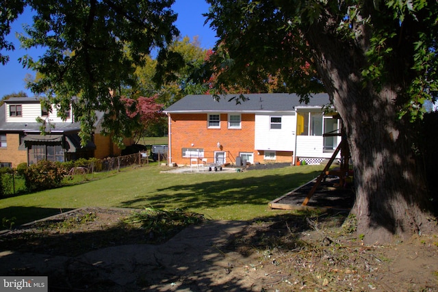 rear view of property with a yard and a patio