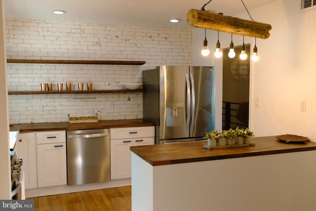 12507 Greenly St, Silver Spring, MD 20906 - kitchen with wood counters, appliances with stainless steel finishes, white cabinetry, light wood-type flooring, and recessed lighting