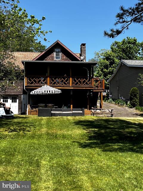 rear view of property featuring a lawn