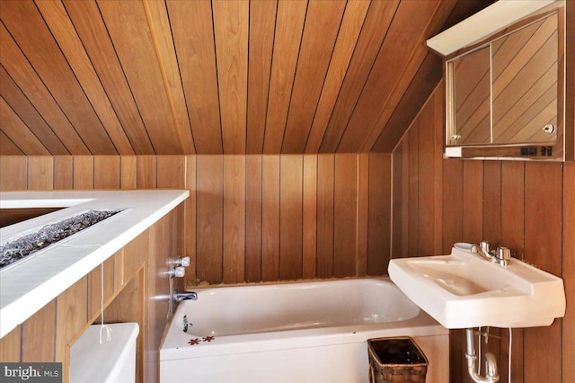 bathroom with wood ceiling, wood walls, lofted ceiling, and a washtub