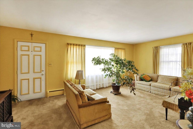 living room featuring a baseboard heating unit, a healthy amount of sunlight, and carpet flooring