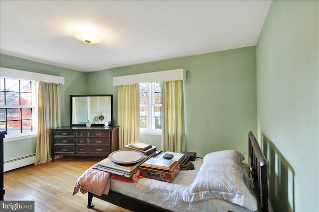 bedroom featuring a baseboard radiator and light wood-type flooring