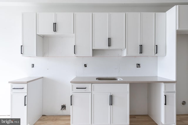 kitchen featuring light wood-type flooring and white cabinetry