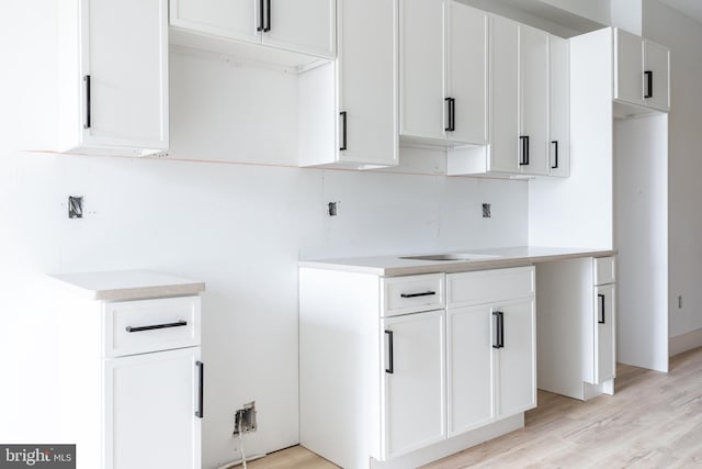 kitchen with light hardwood / wood-style floors and white cabinets