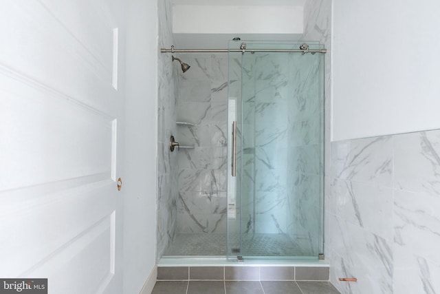 bathroom featuring tile walls and a shower with shower door