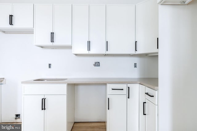 kitchen with sink, white cabinets, and light hardwood / wood-style floors