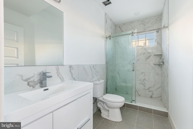 bathroom featuring vanity, a shower with shower door, tile walls, and toilet