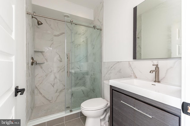 bathroom with tile walls, vanity, an enclosed shower, and toilet