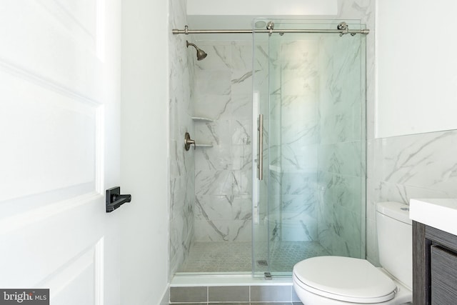 bathroom with toilet, vanity, and an enclosed shower