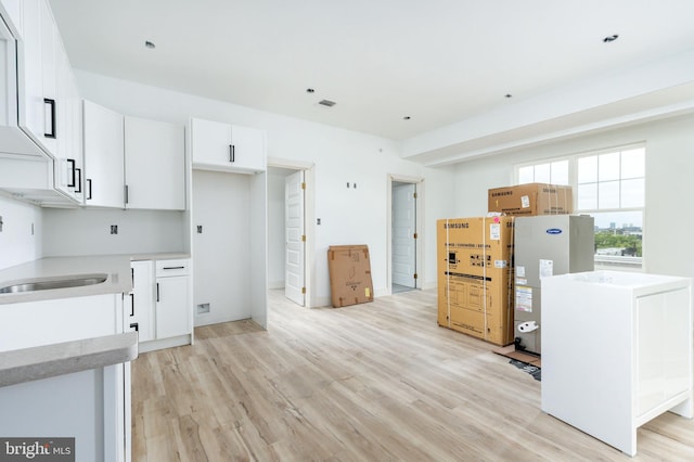 kitchen with sink, white cabinets, and light hardwood / wood-style floors