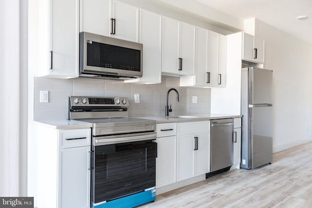 kitchen with appliances with stainless steel finishes, sink, and white cabinetry