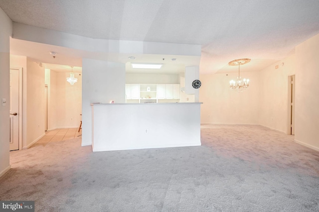 unfurnished living room with a textured ceiling and light colored carpet