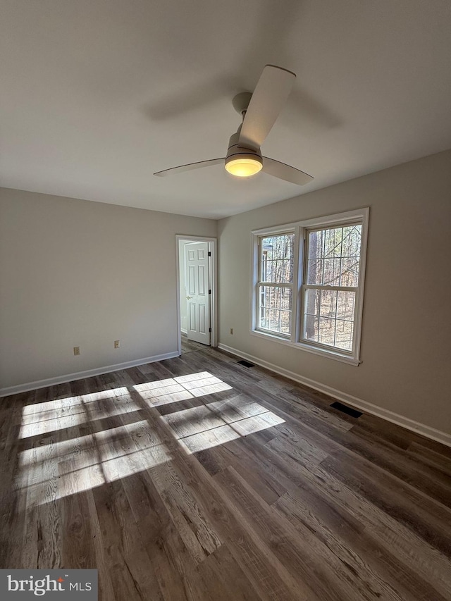 empty room with ceiling fan and dark hardwood / wood-style floors