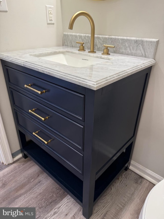 bathroom featuring vanity, wood-type flooring, and toilet