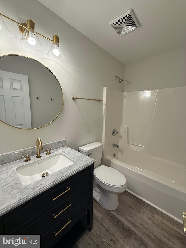 full bathroom featuring  shower combination, toilet, hardwood / wood-style floors, and vanity